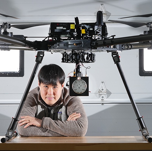 Faculty sits with drone 
