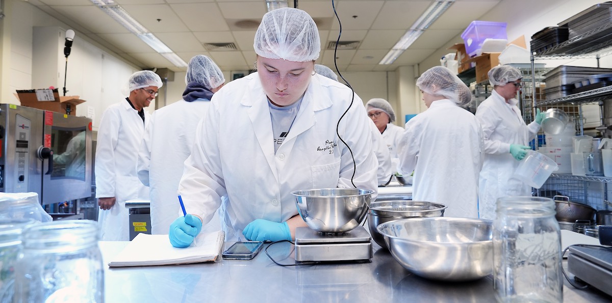 Student preparing product recipes for use in Skidmore Lab.
