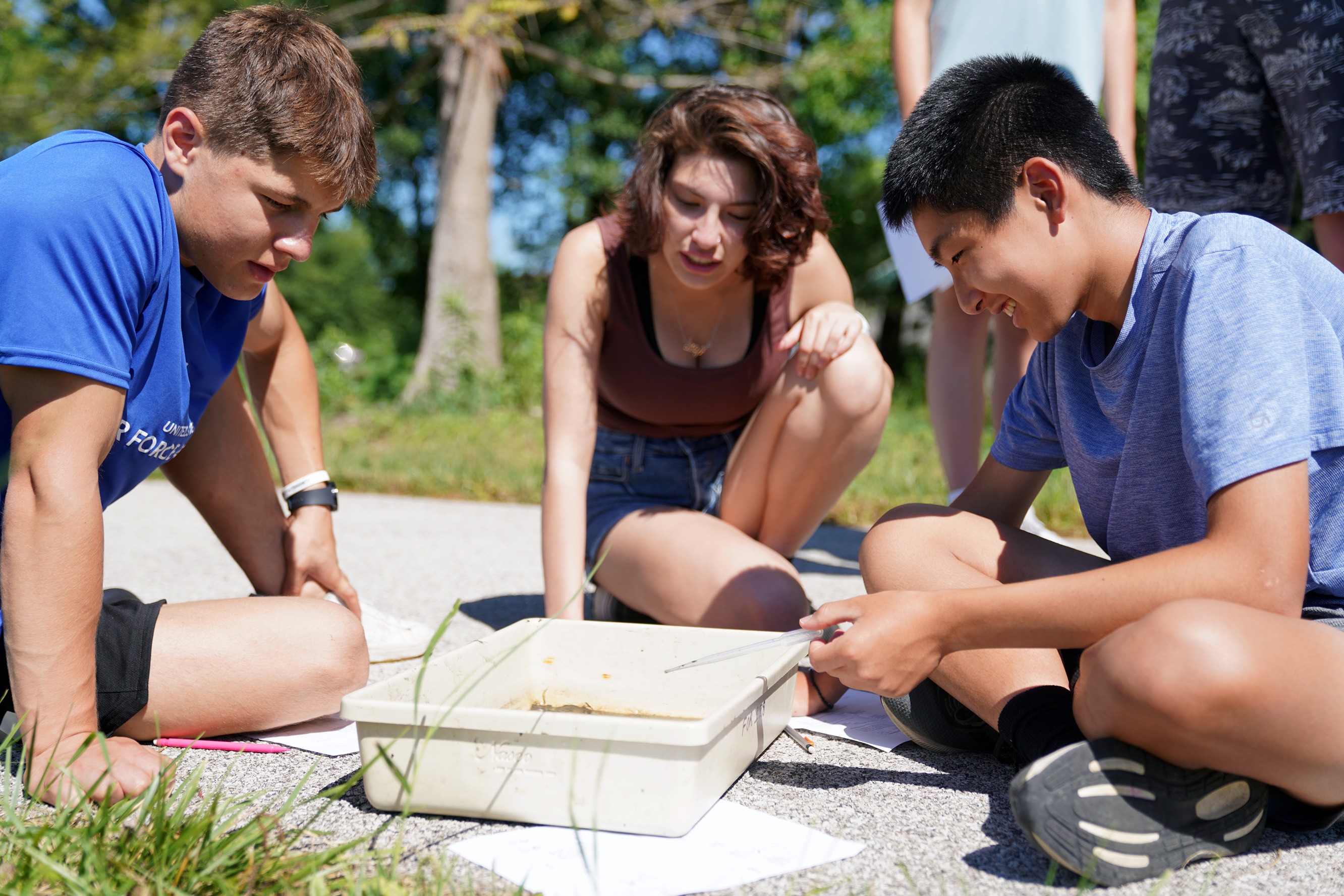 High school students observe the contents of a water sample.