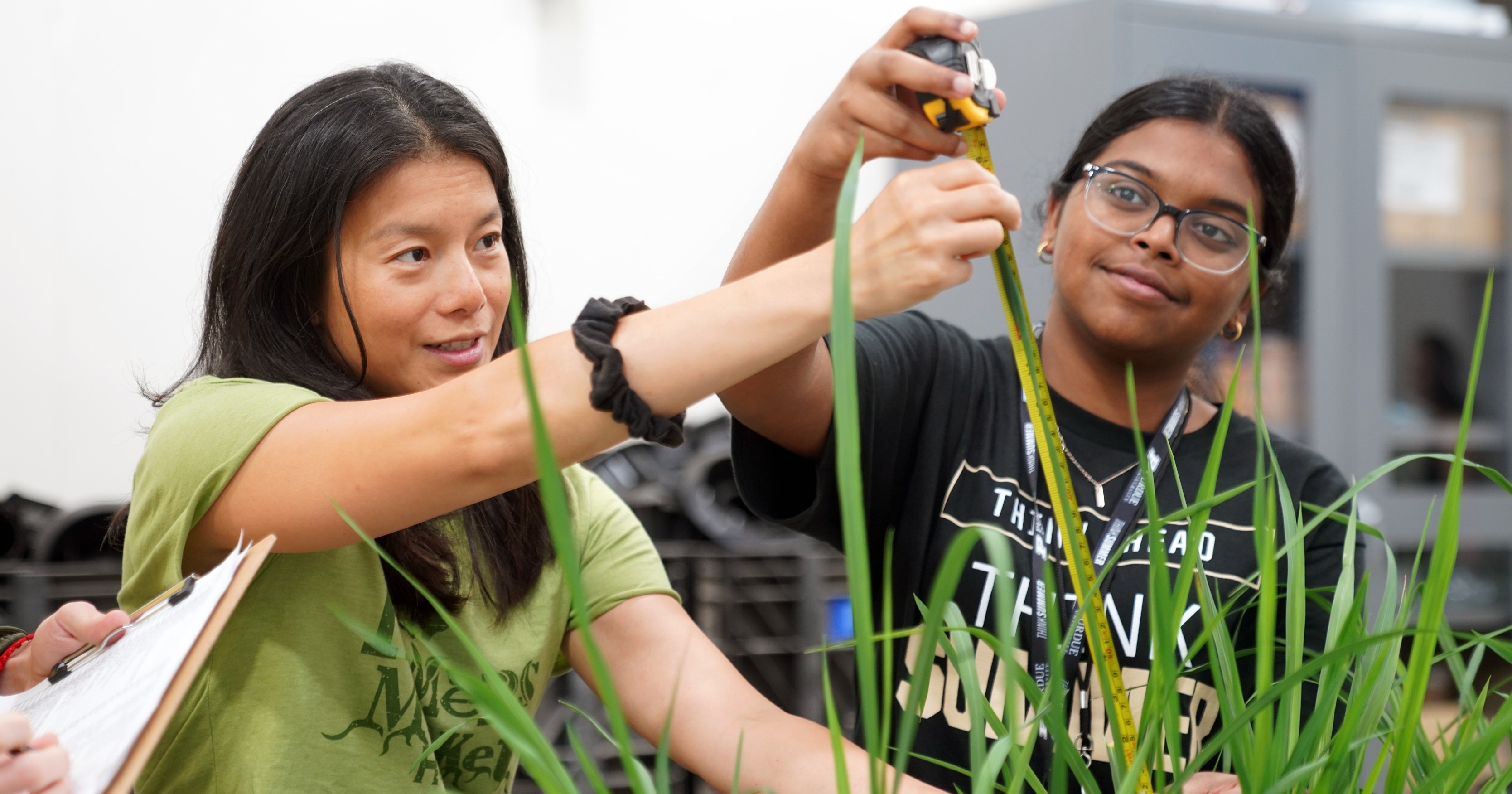 Diane Wang gathers plant data with a student.