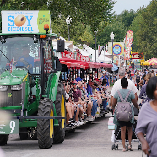 Fairgoers ride a tractor, sponsored by the Indiana Soybean Alliance, and browse food tents during the 2023 Indiana State Fair. (Purdue Agricultural Communications photo)