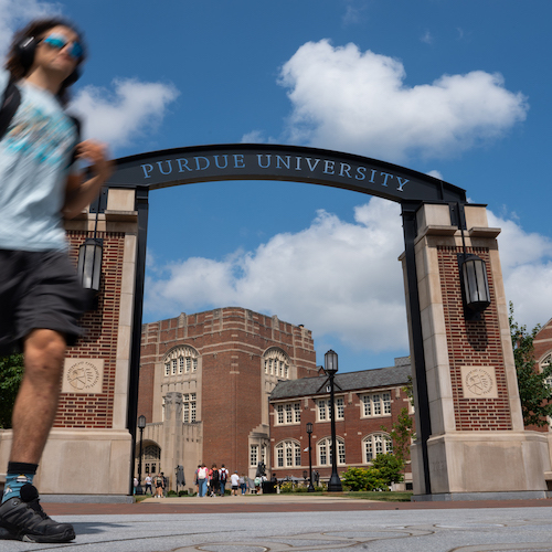 The Purdue arch with students going to their first day of classes.