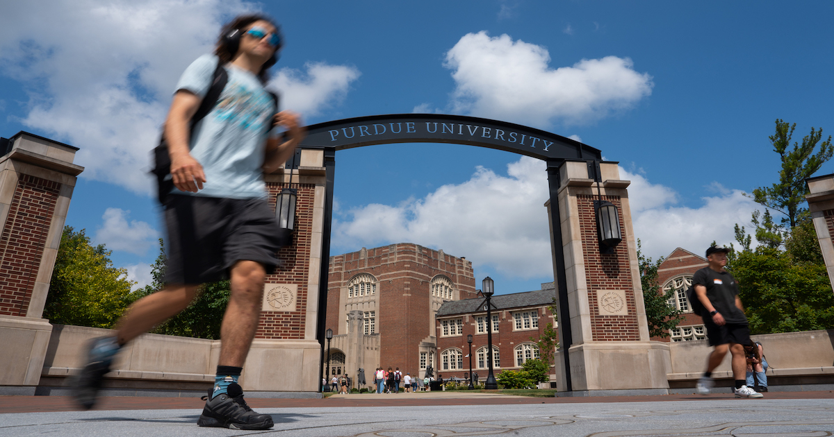 The Purdue arch with students going to their first day of classes.