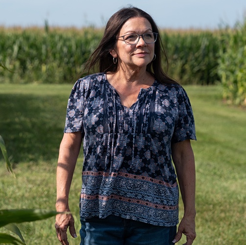 Kimber Nicoletti-Martinez walking through a cornfield in Indiana