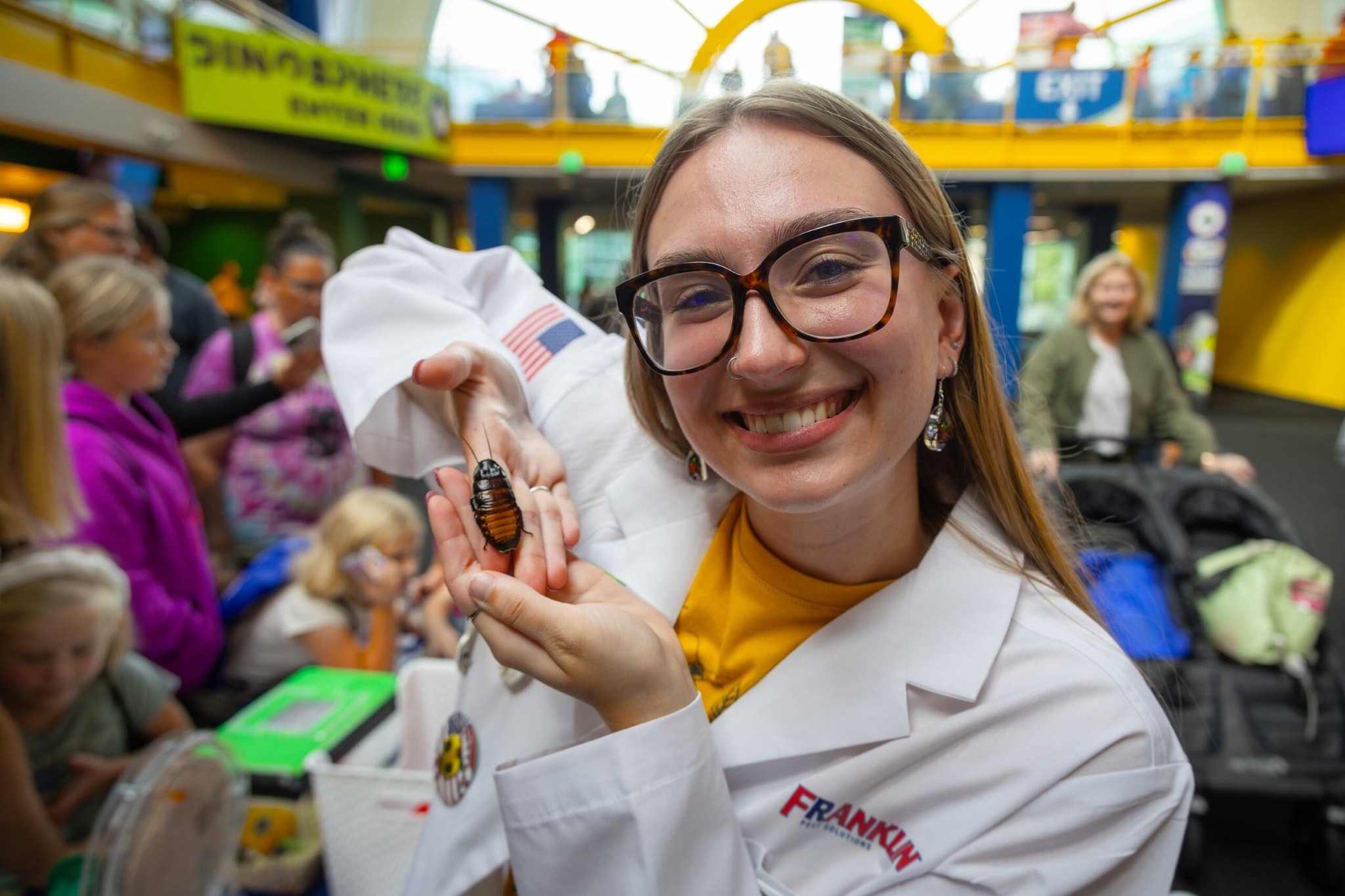 Allison Beach holds a cockroach and smiles