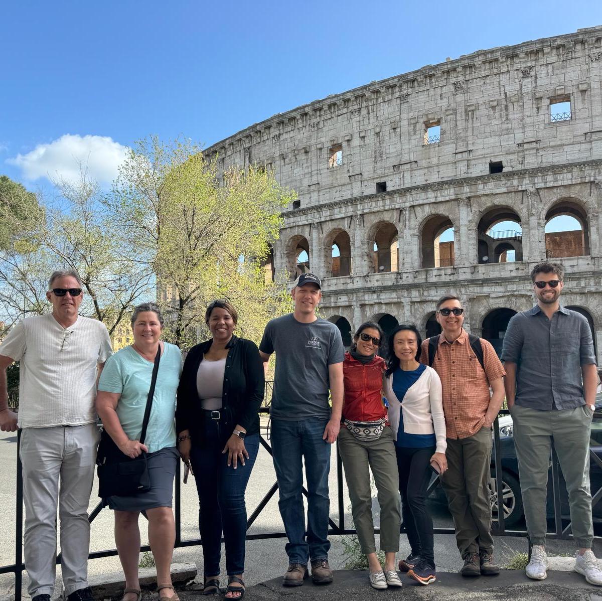 Purdue faculty stand in front of coloseeum in Rome.