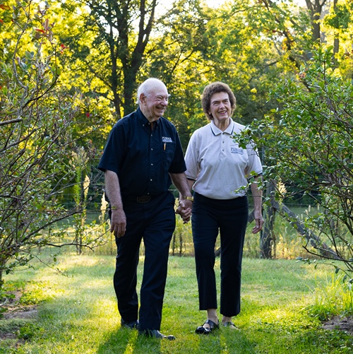 Marshall and Berdine Martin walk hand in hand at their family farm