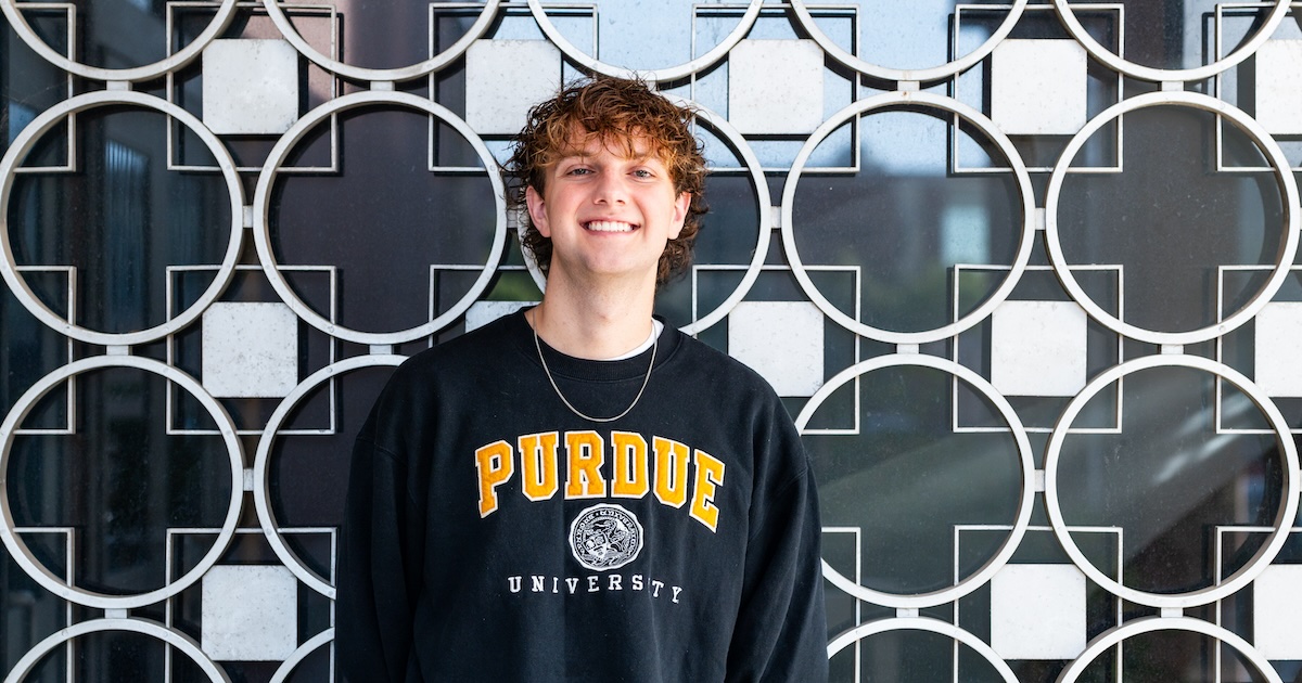 Nicholas Neuman, a junior in the departments of agricultural economics and political science, smiling in Purdue University's Krannert Building.