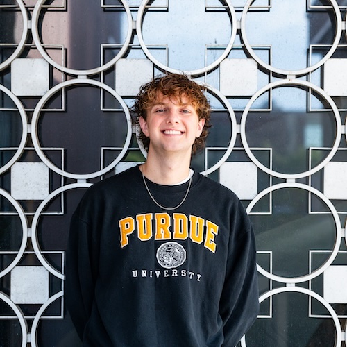 Nicholas Neuman, a junior in the departments of agricultural economics and political science, smiling in Purdue University's Krannert Building.