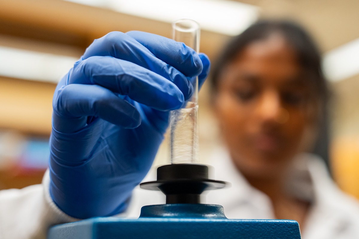 shreya vortexes a sample of clear liquid in a glass test tube