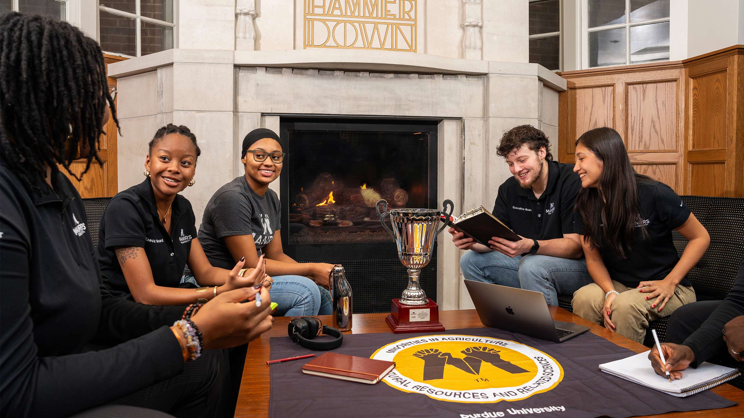 MANRRS officers Morgan Murff, Matrie Irving, Megan McCoy, Otto Hoehl and Alejandro Prado relax around a fireplace at the Purdue Memorial Union.