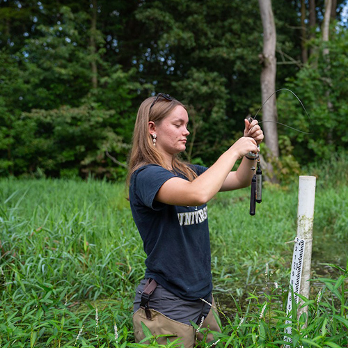 Alexus Arvin takes a water sample at the Agronomy Center for Research and Education.
