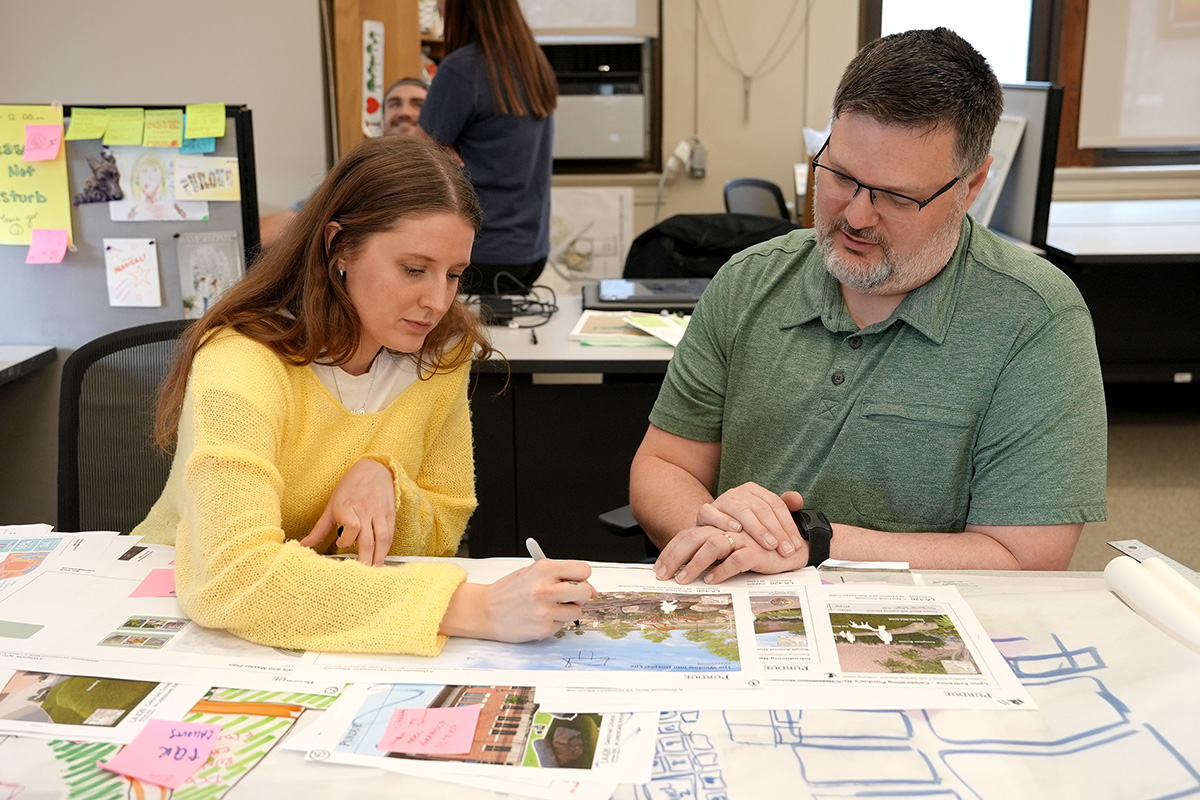 Mary Schultz and her advisor Aaron Thompson look over the landscape plans for the vet school