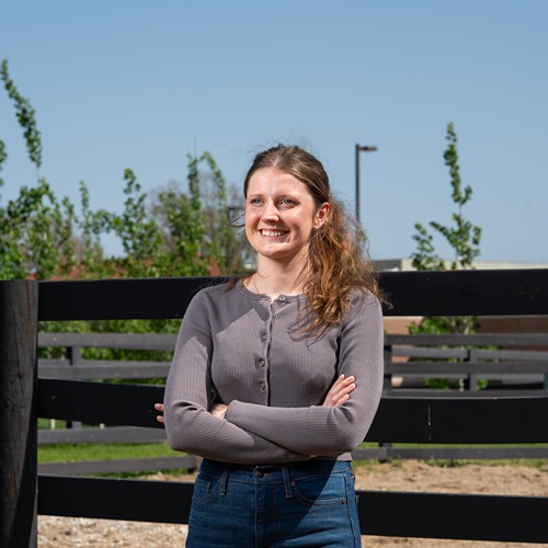 Mary Schultz stands in front of a horse paddock at the Purdue vet hospital