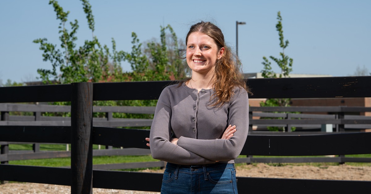 Mary Schultz stands in front of a horse paddock at the Purdue vet hospital
