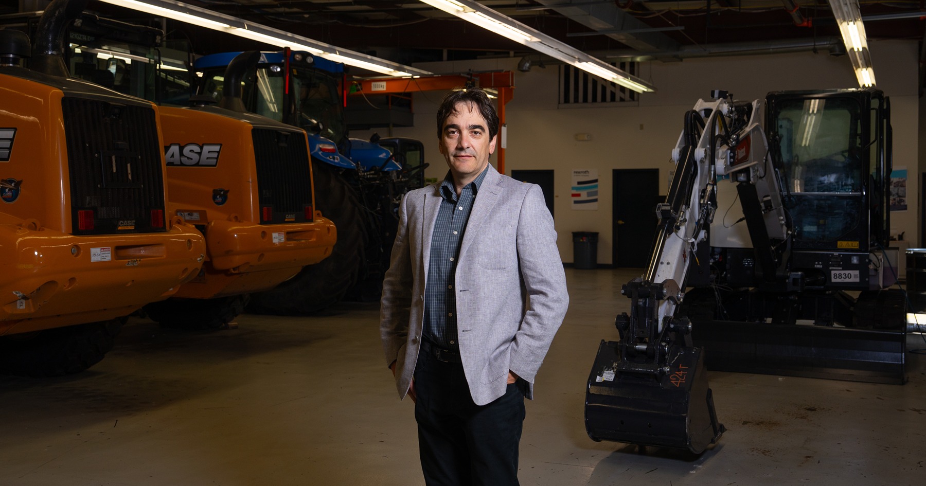 andrea vacca stands in Maha facility in front of construction vehicles