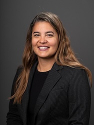 Portrait of Fernanda de Cunha in front of grey backdrop.