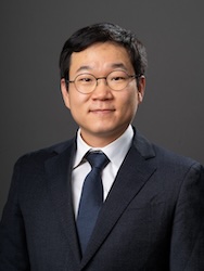 Portrait of Jinsu Hong in front of grey backdrop.