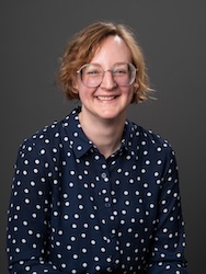 Portrait of Lisa Mydy in front of grey backdrop.