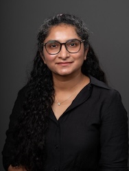 Portrait of Rubab Saher in front of grey backdrop.