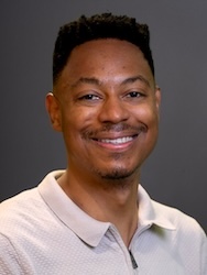 Portrait of William Scott in front of grey backdrop.
