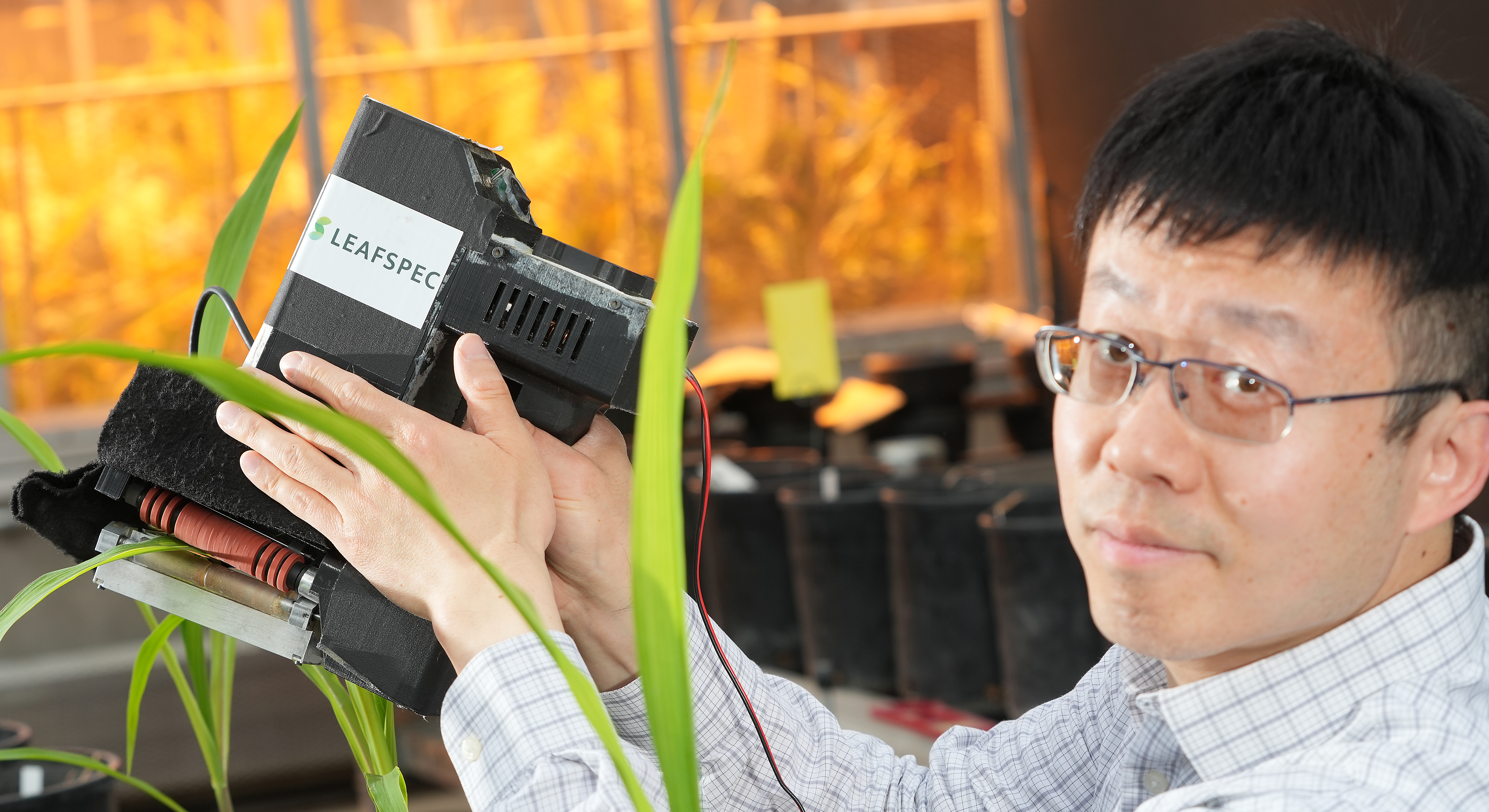 Jian Jin, associate professor in agricultural and biological engineering, demonstrating LeafSpec, an accurate, affordable and portable hyperspectral crop leaf imager innovated in Purdue'ABE Plant Sensor Lab.