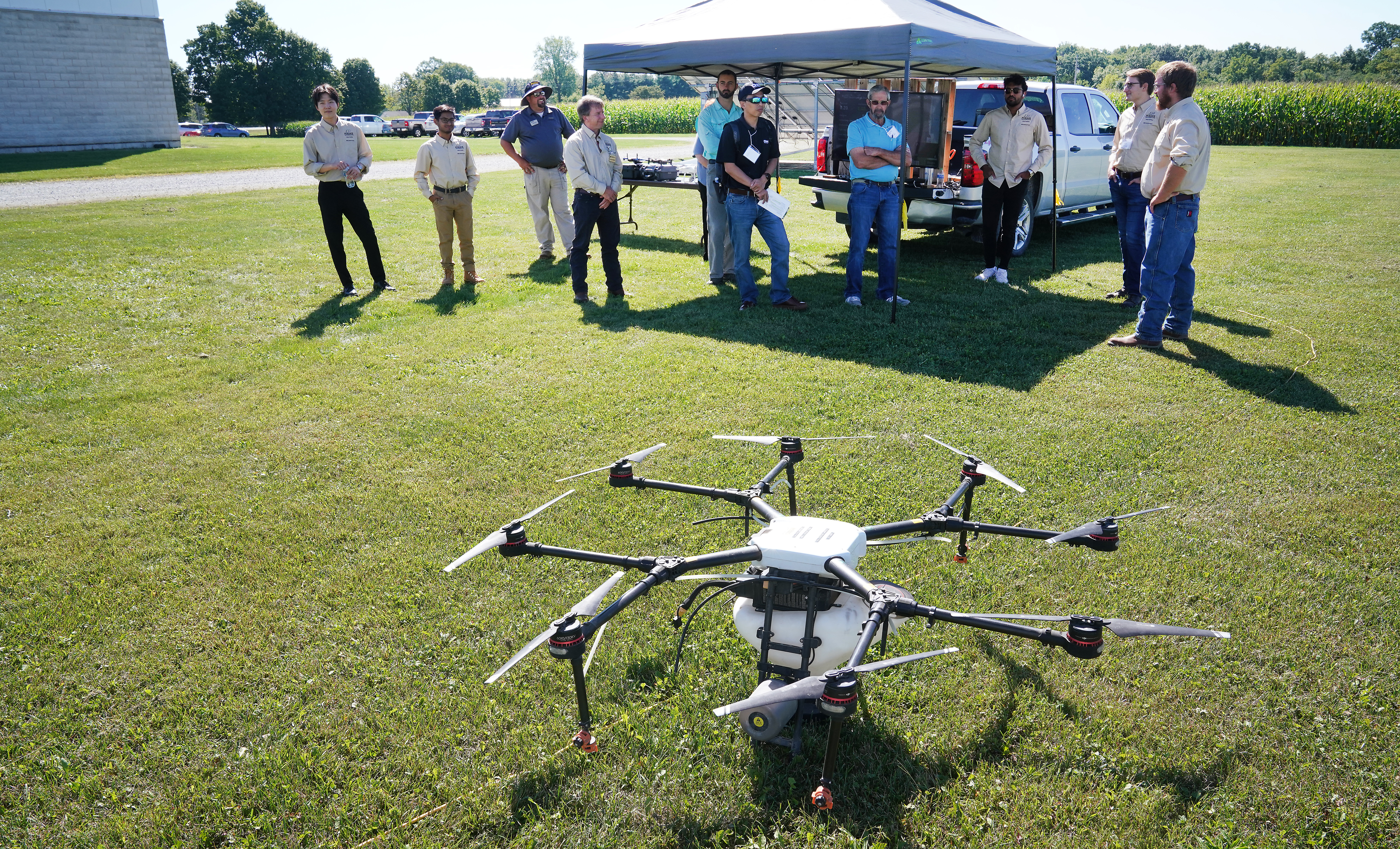 Attendees of the Digital Agriculture Showcase at Agronomy Center for Research and Education watching a drone prepare for flight.