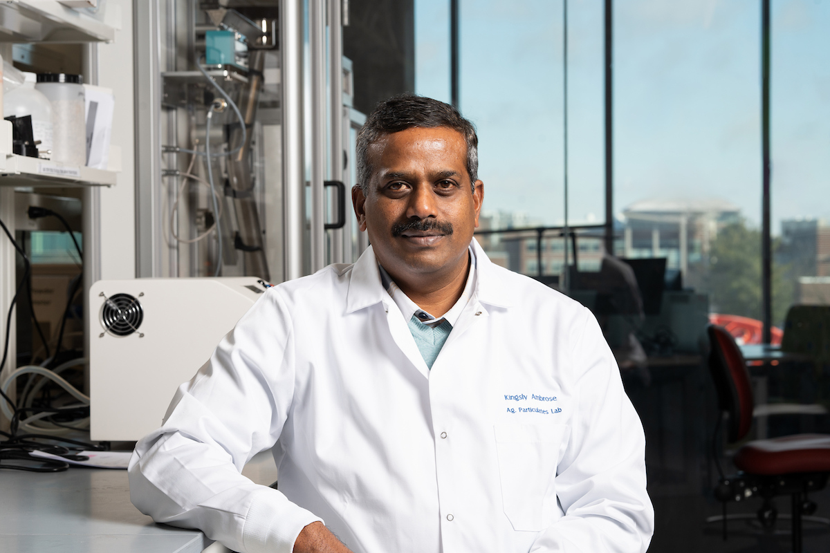 Headshot of Kingsly Ambrose in a lab within the Department of Agricultural and Biological Engineering, wearing a lab coat.