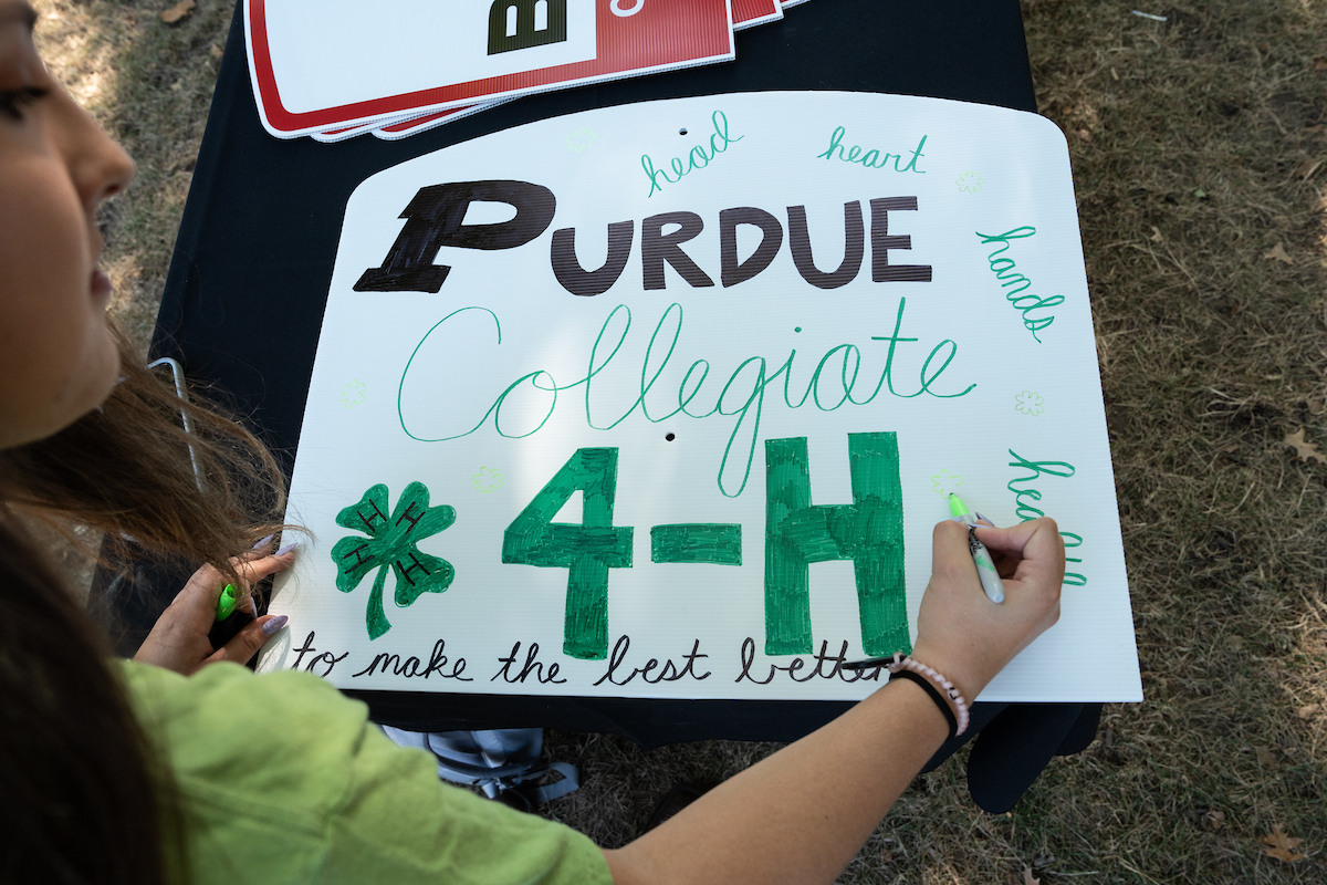 Student creating a 4-H sign for the AgDay College Roadshow.