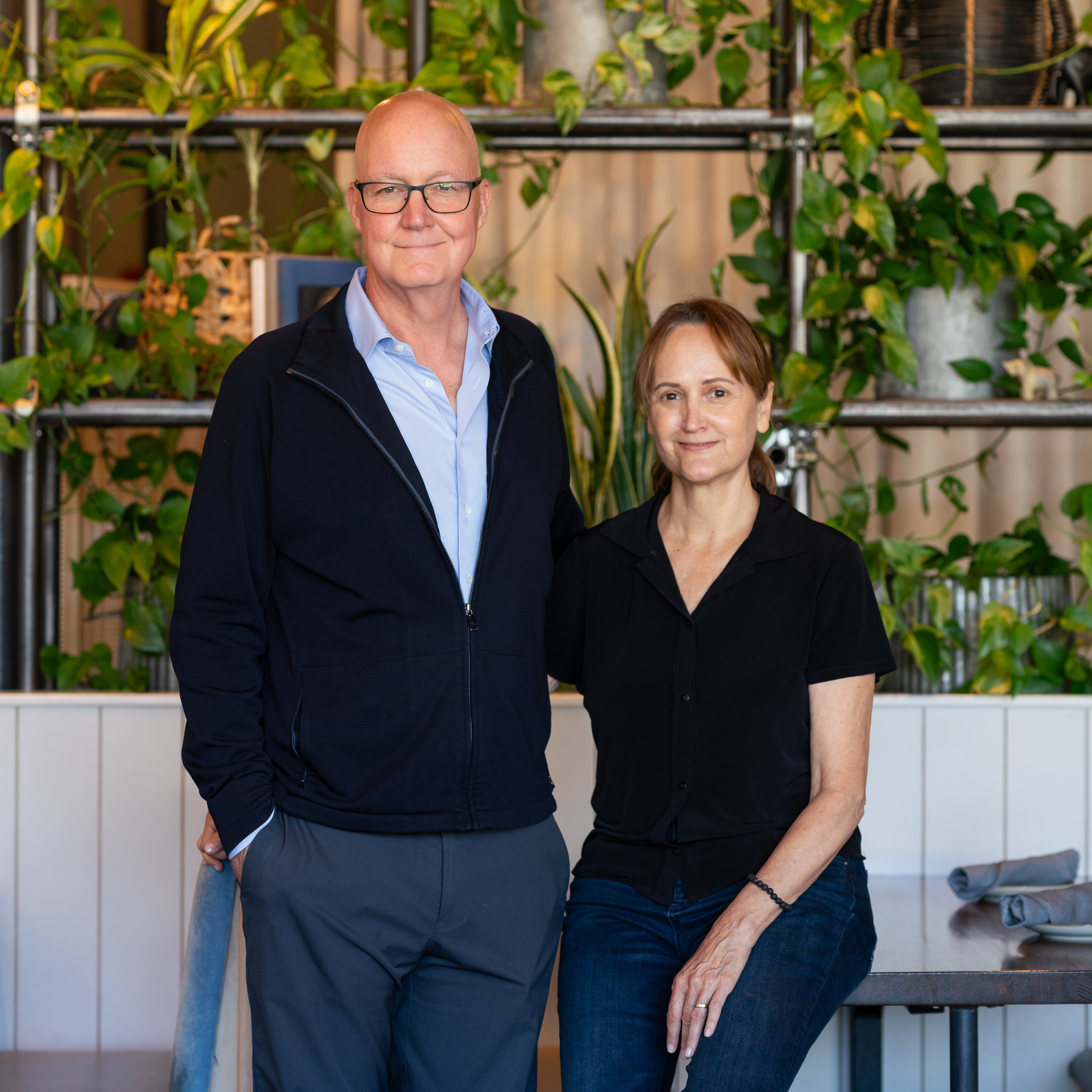 Bill and CD Young at a table in front of greenery in the Spirit and Elephant restaurant.