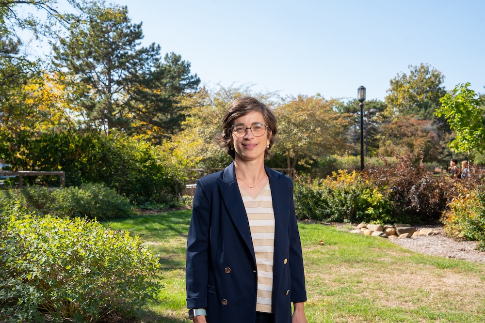 Ellen Van Loo, associate professor in the Department of Agricultural Economics, standing in front of greenery on Purdue's West Lafayette campus.