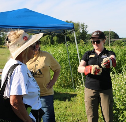 ashley adair wears gloves and presents to farmers during a field day