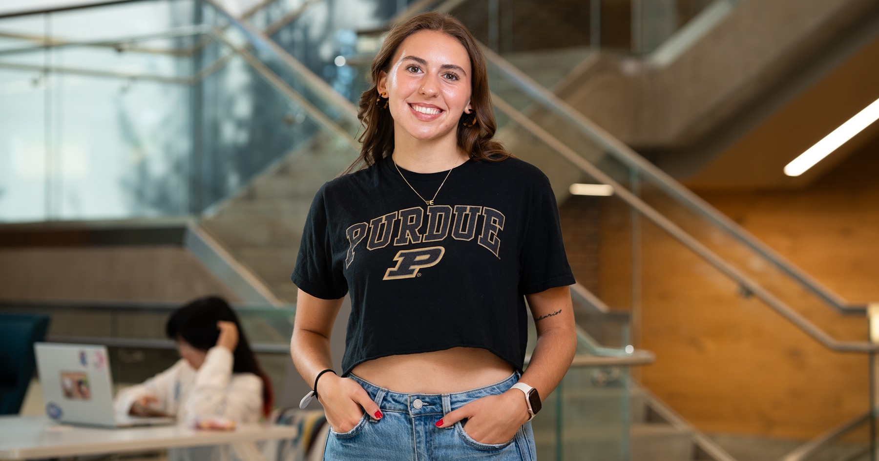 Meghan Haws in a Purdue T-shirt posing in front of a staircase