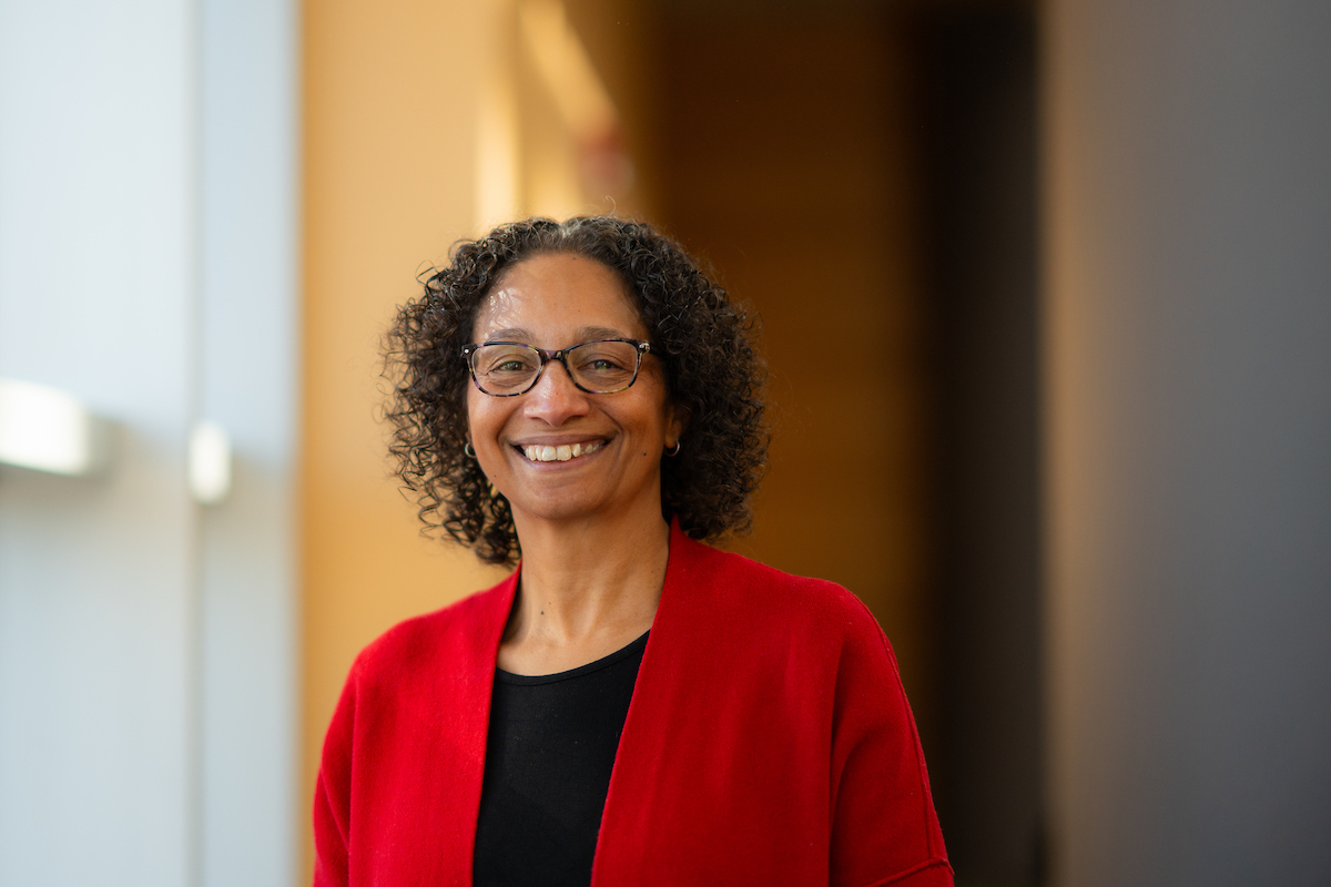 Headshot of Maria Marshall standing in a hallway of an academic building smiling.