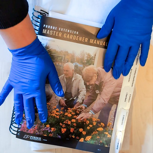 hands on top of a book with parchment paper tucked inside