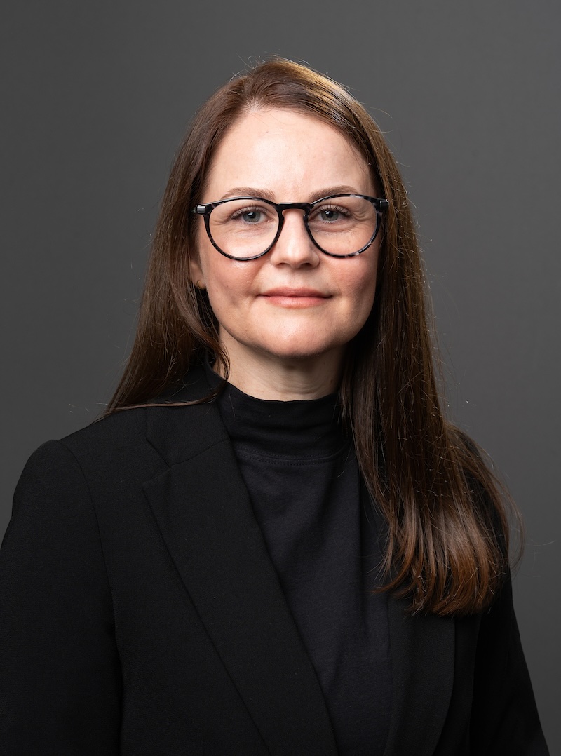 Headshot of Camila Nicolli in front of a grey backdrop.