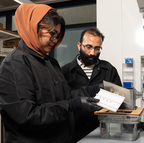 Mohit Verma in lab with grad student 