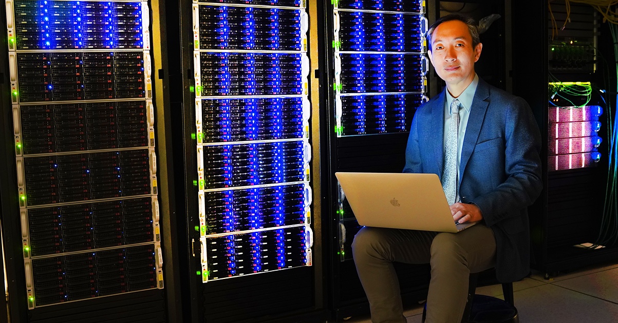 Man works on a laptop at a computing center.