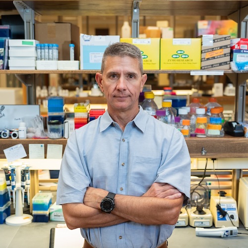 Andrew DeWoody stands in front of test equipment in his lab in West Lafayette, Ind.