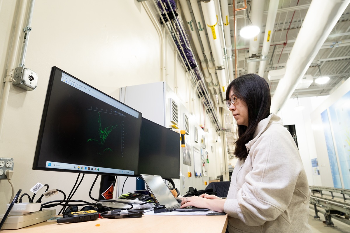 Xiaomeng sits at a computer in the AAPF with her green point cloud model on the screen