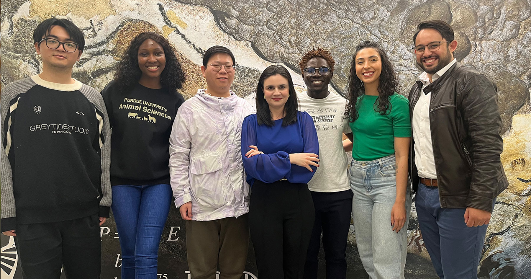 Students and a professor stand together.