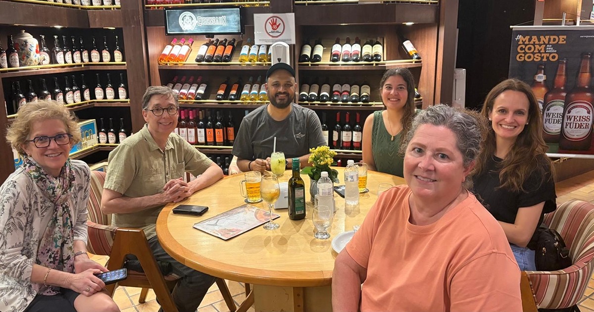 IRA cohort sits around table during visit to Brazil