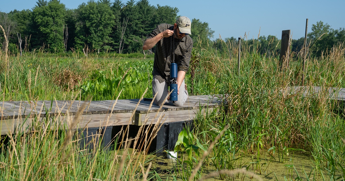 Scientist uses 3D water sensor near water.
