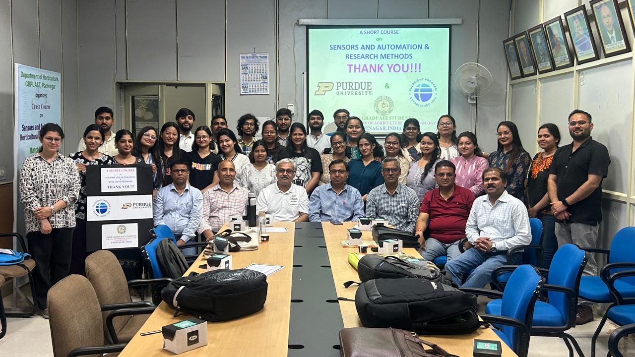 MS and Ph.D. students with Nemali inside a classroom, powerpoint in the background that reads, "a short course on sensors and automation & research methods."