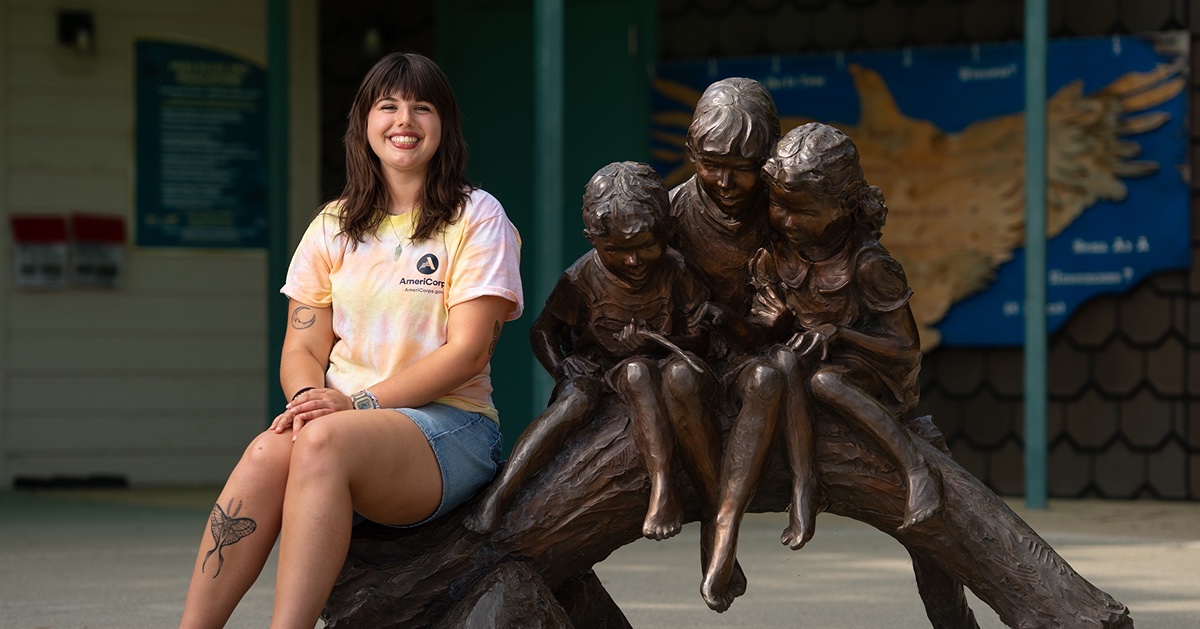 Meghan Hartman by statue with children at the Celery Bogg Nature Center.