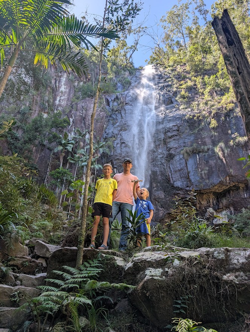 Meyers and his two sons in front of a waterfall in Australia.
