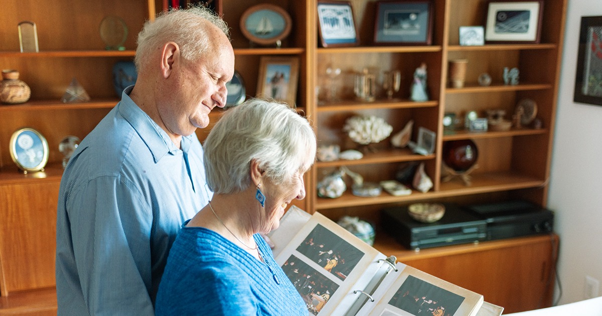 Bob Thompson looks at photo album with wife
