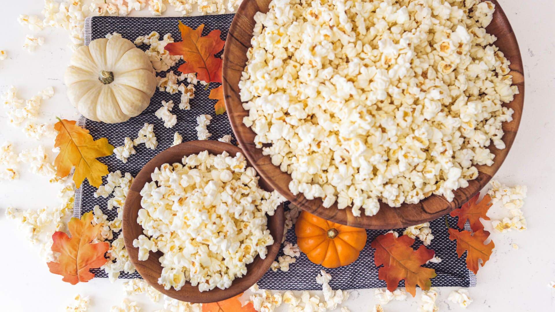 table setting with bowl of popcorn and fall decorations