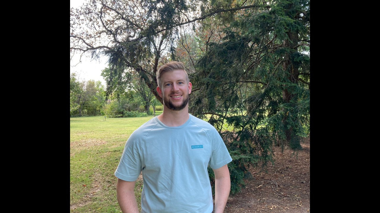 a man smiling in front of a tree