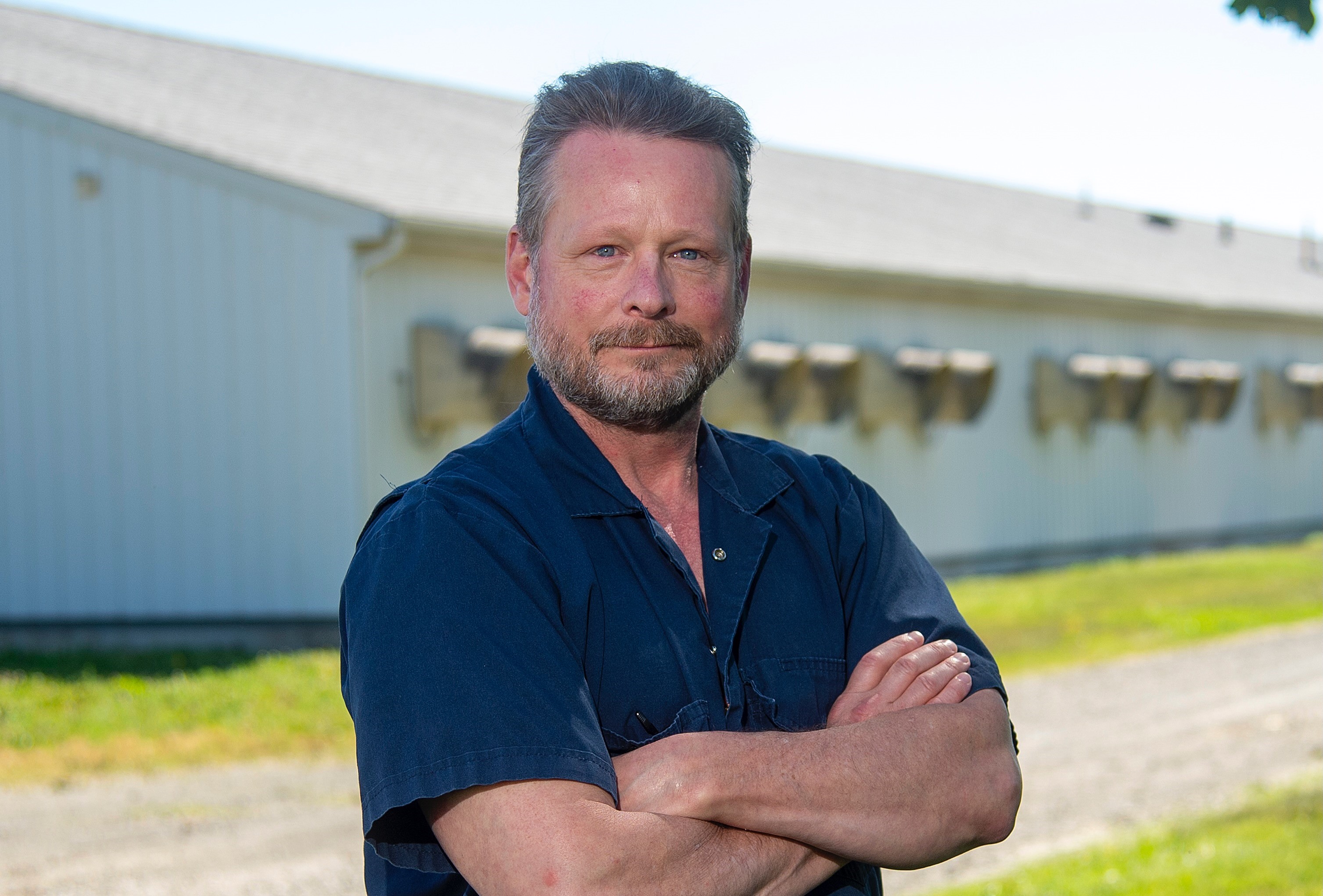 a man in front of a barn